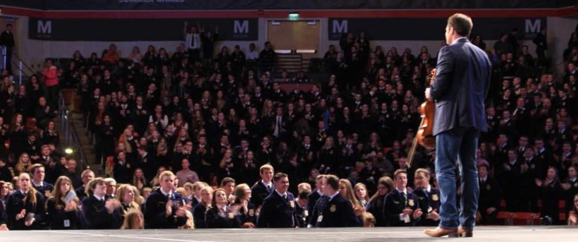 A crowd of people sitting in front of a large audience.